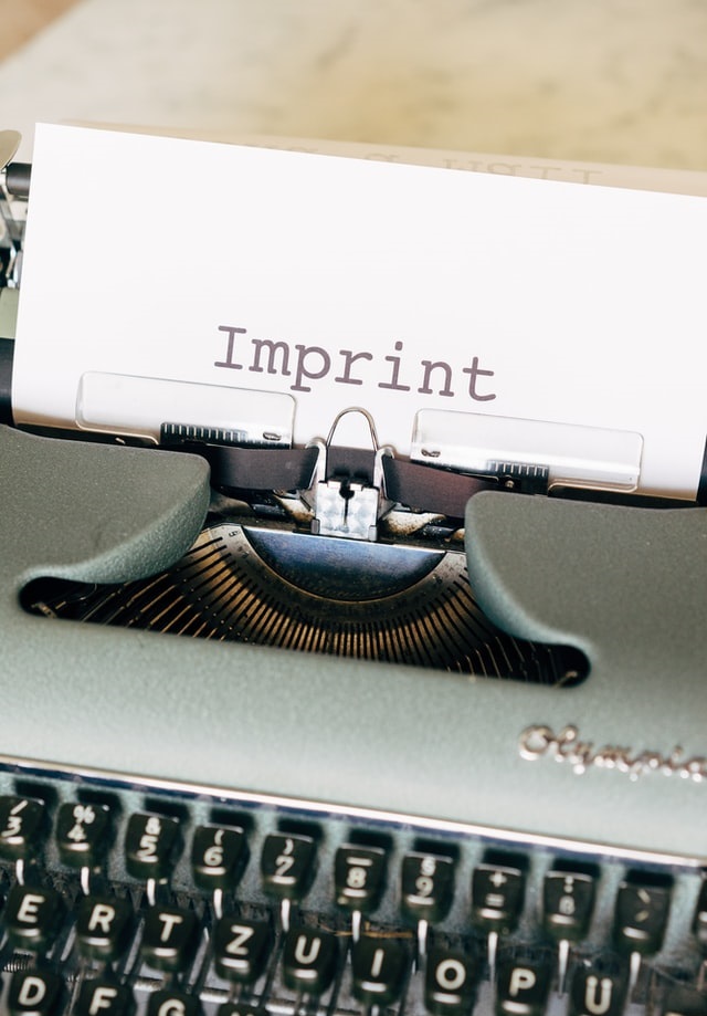 Typewriter with piece of paper that says "Imprint"